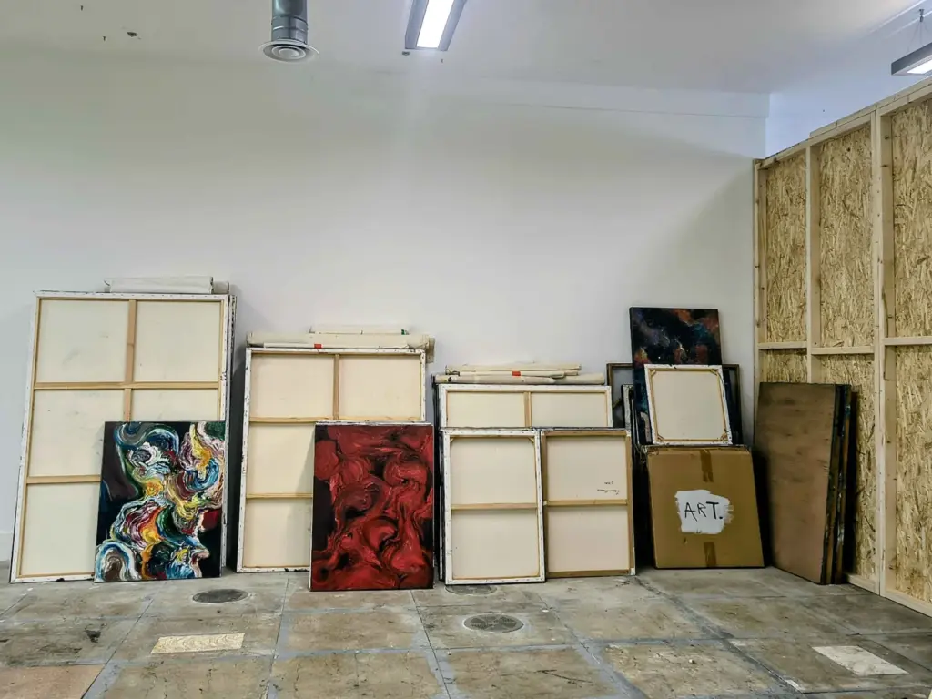 Canvases and paintings stacked against the wall at Studio BRUT