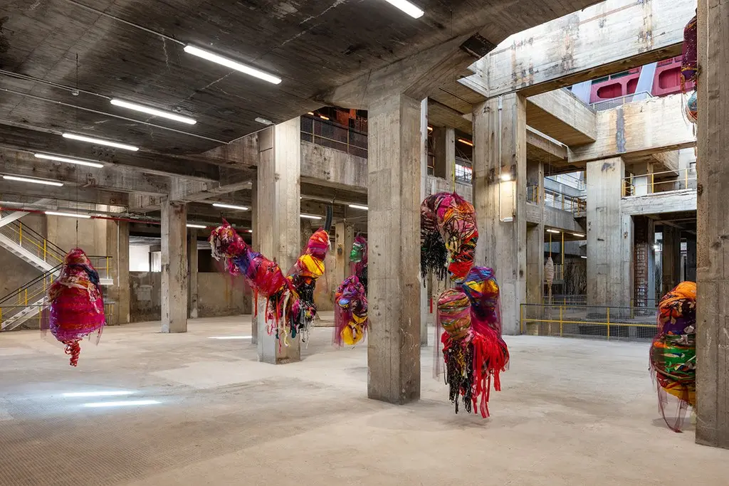 Suspended cocoon sculptures by Nnena Kalu, wrapped from fabric, tape and paper.