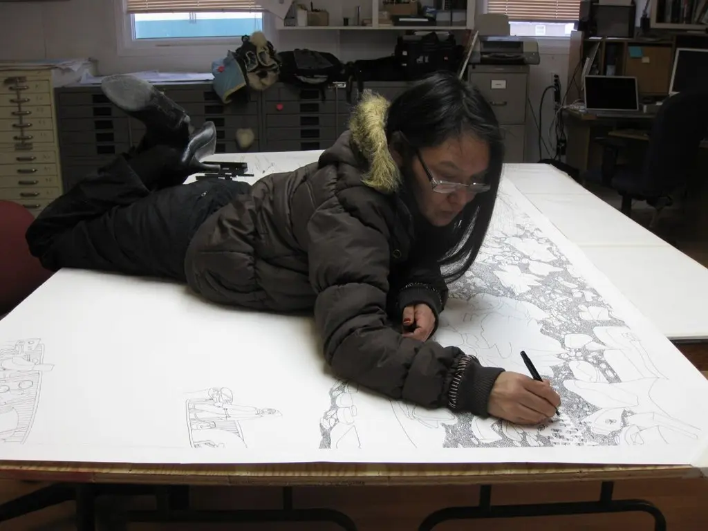 Shuvinai Ashoona working on a large drawing at the Kinngait Studios.