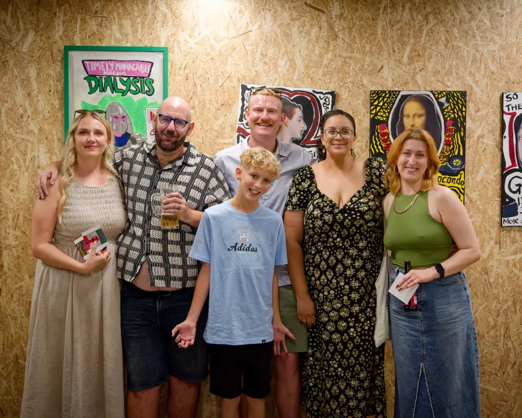 A group of guests in front of artworks at the Studio BRUT opening night, Swindon