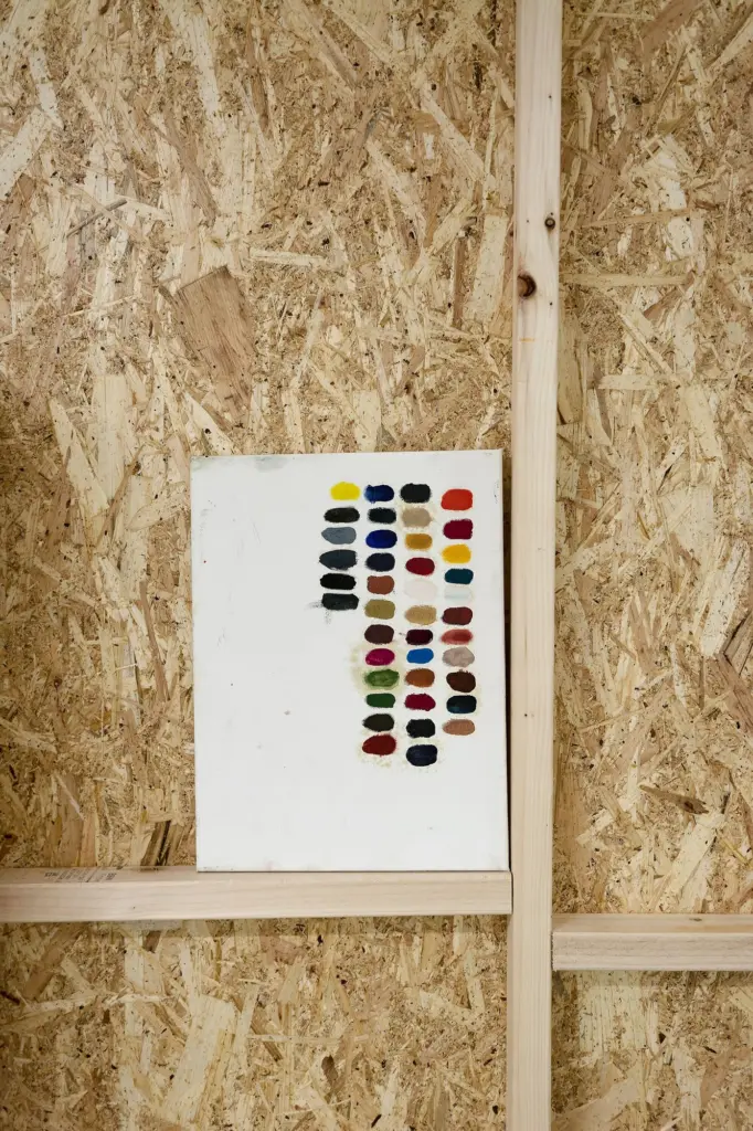 A grid of painted colour swatches on a board wall