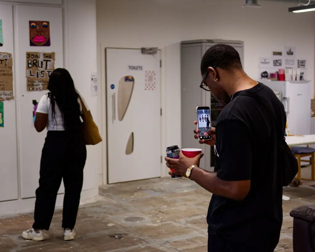 Two visitors looking at artwork in the studio corridor
