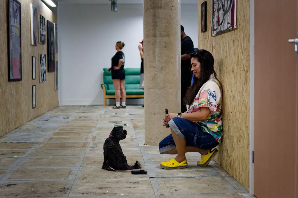 A guest seated in the corridor beneath the hung works
