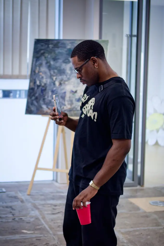 A visitor considering a large grey abstract painting on an easel