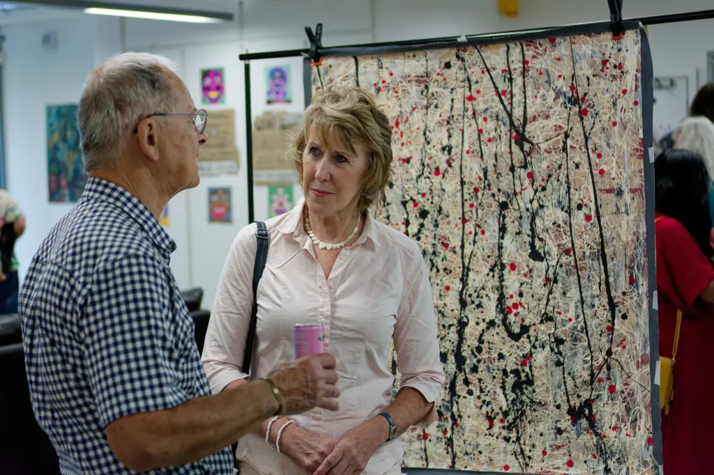 Guests talking in front of a large textile work