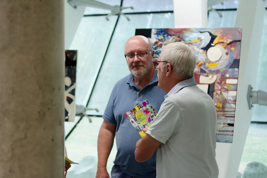 Two guests in conversation beside the studio glass