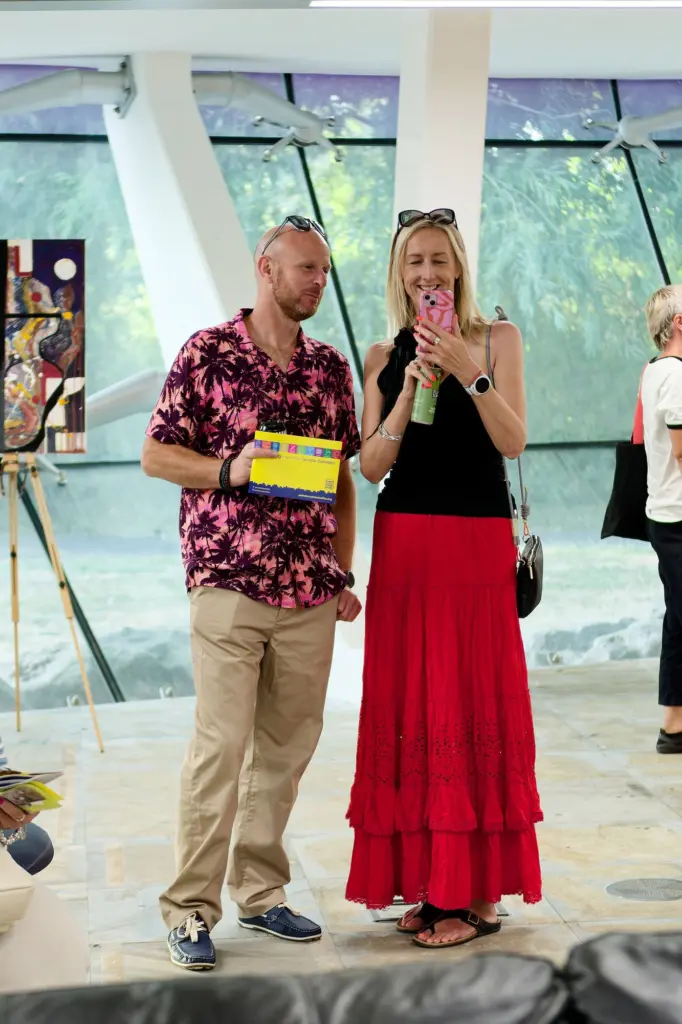 Two guests posed together in front of hung artwork
