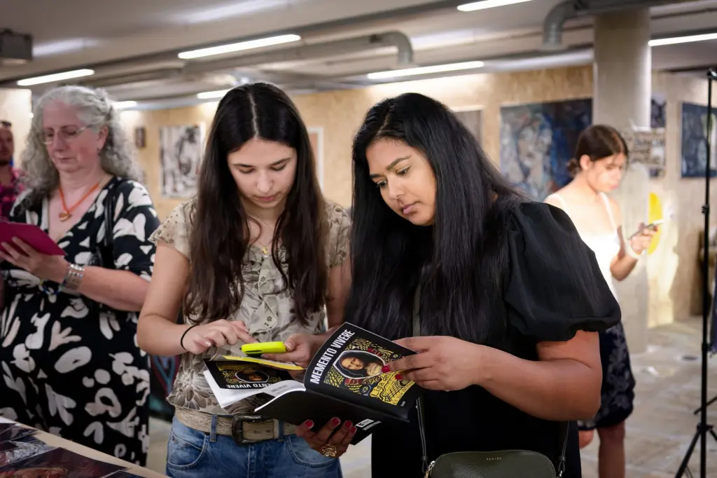 Visitors looking through a book together at the opening
