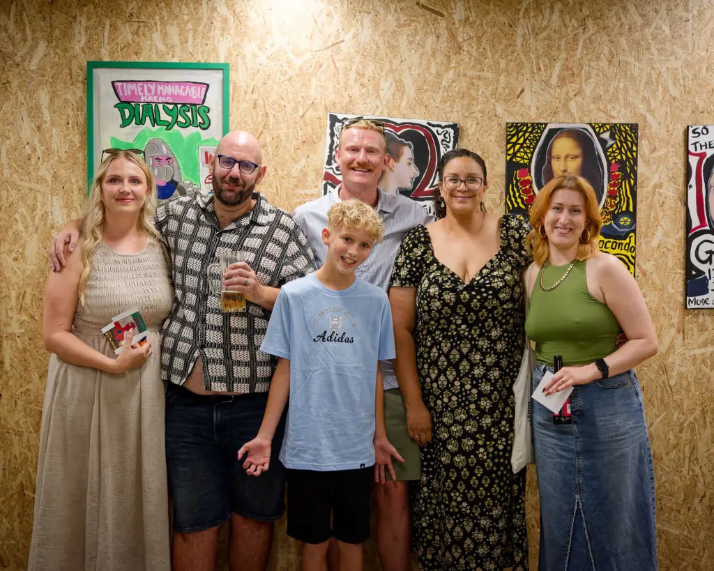 A large family group posed together in the exhibition space