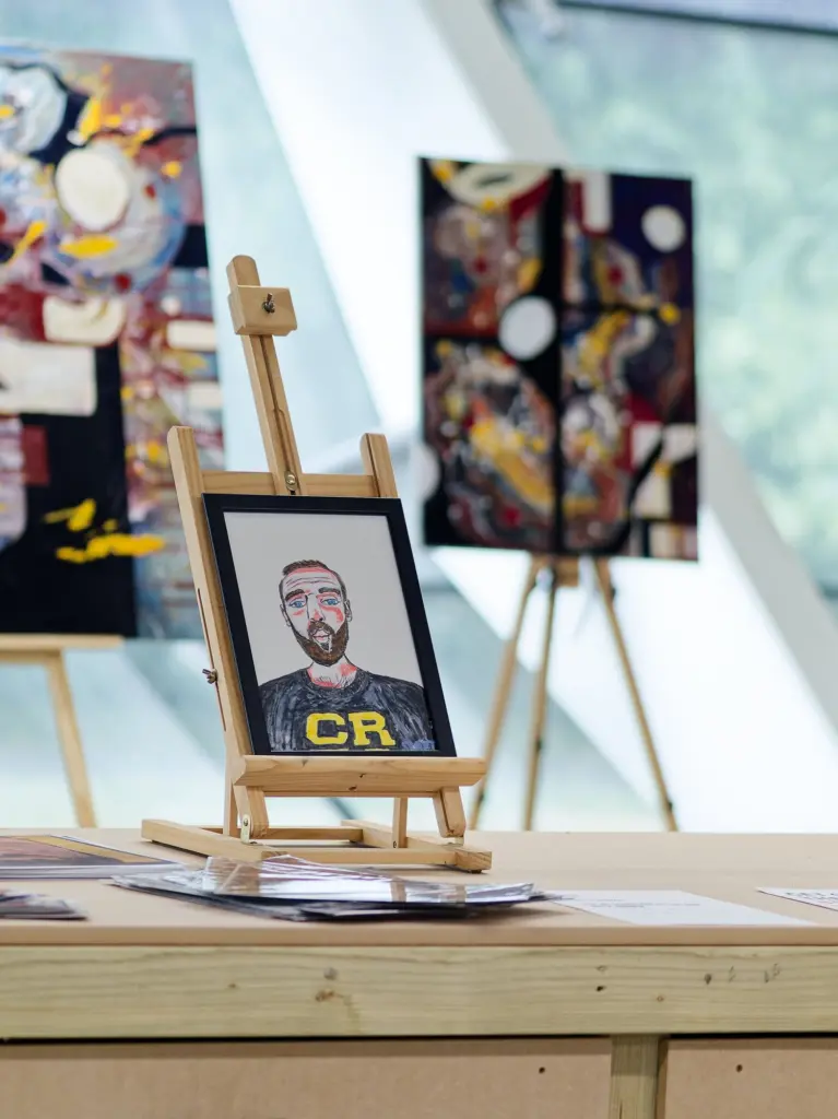 A painted portrait and artworks displayed on easels