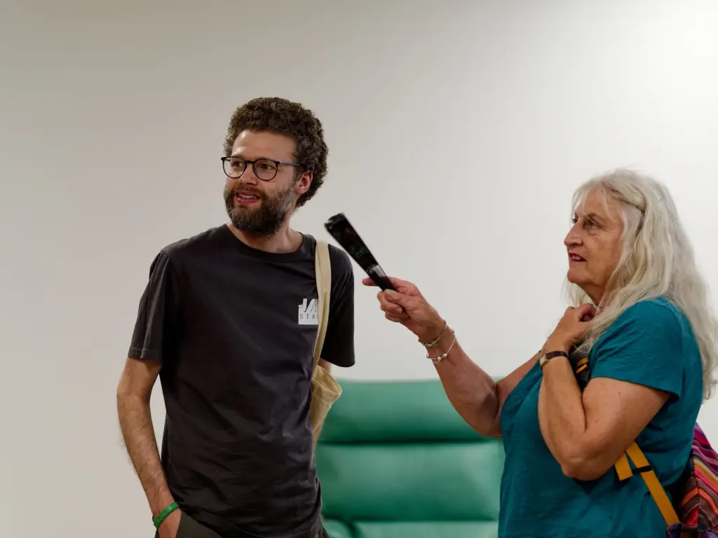 A guest being interviewed with a microphone at the opening