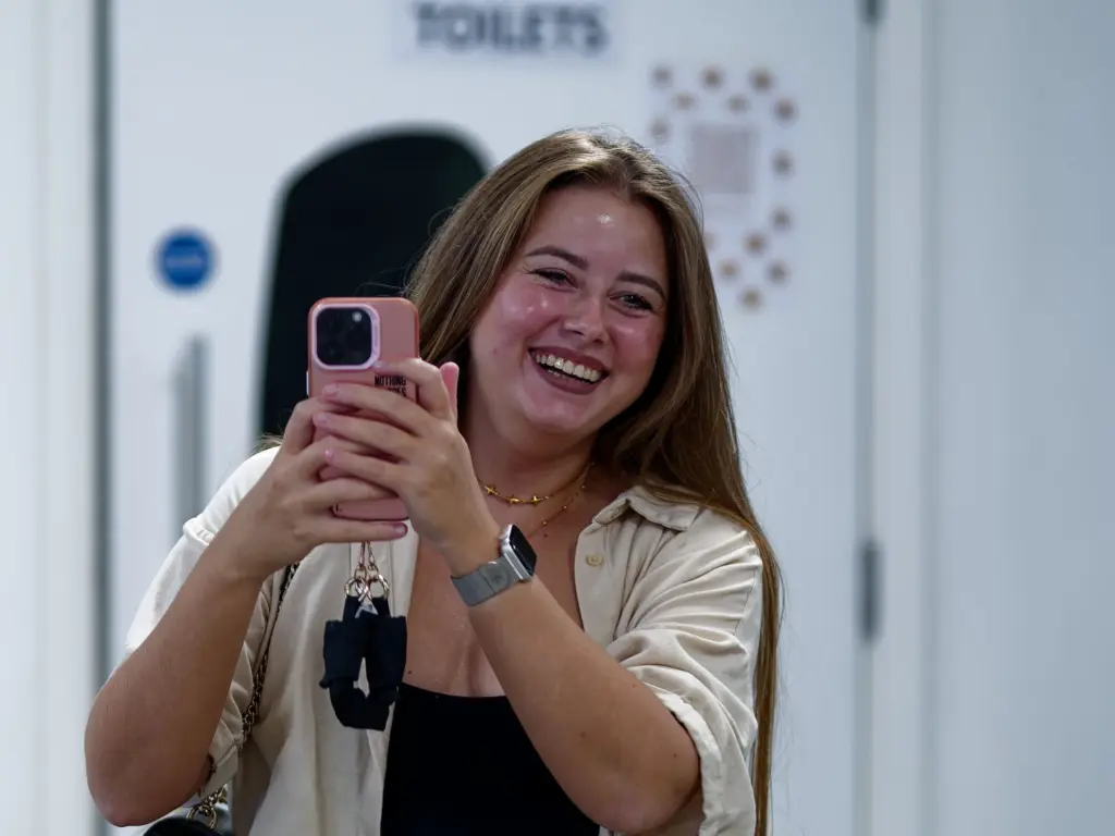 A guest photographing the exhibition on a phone