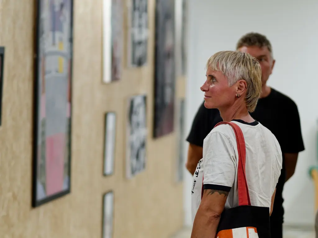 A guest looking at the framed works along the corridor