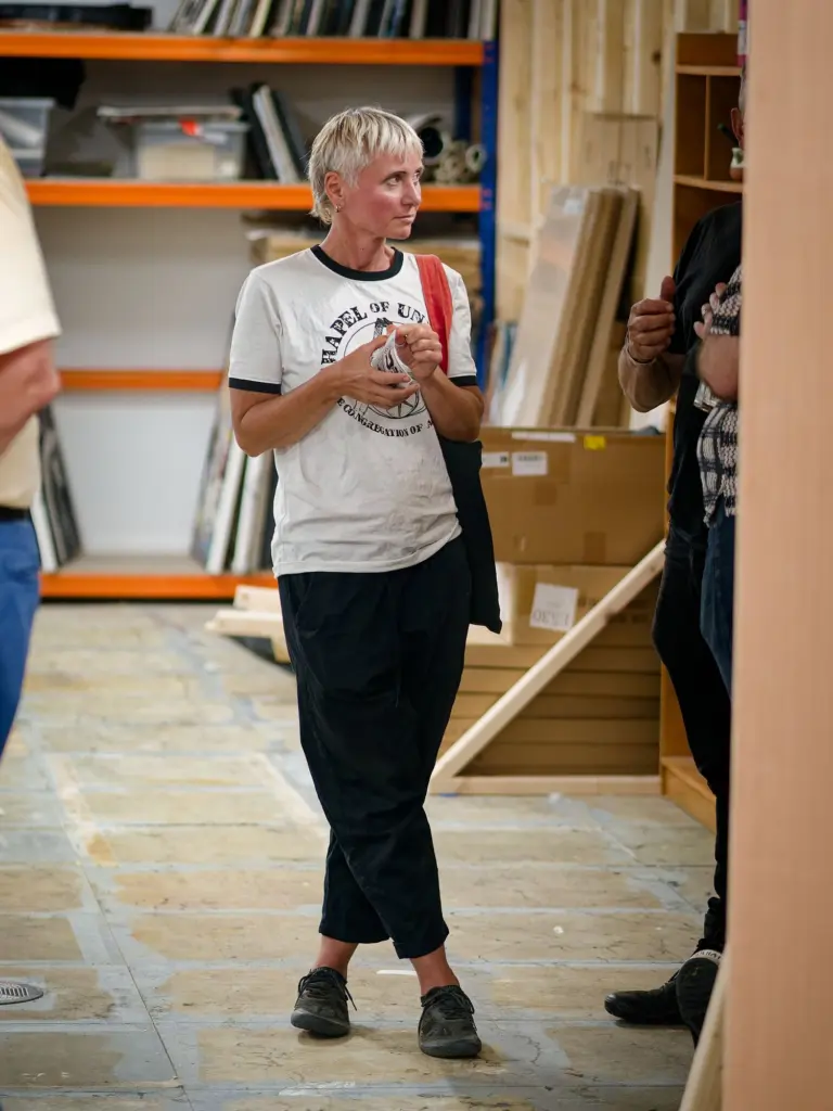 A guest standing with a drink in the studio