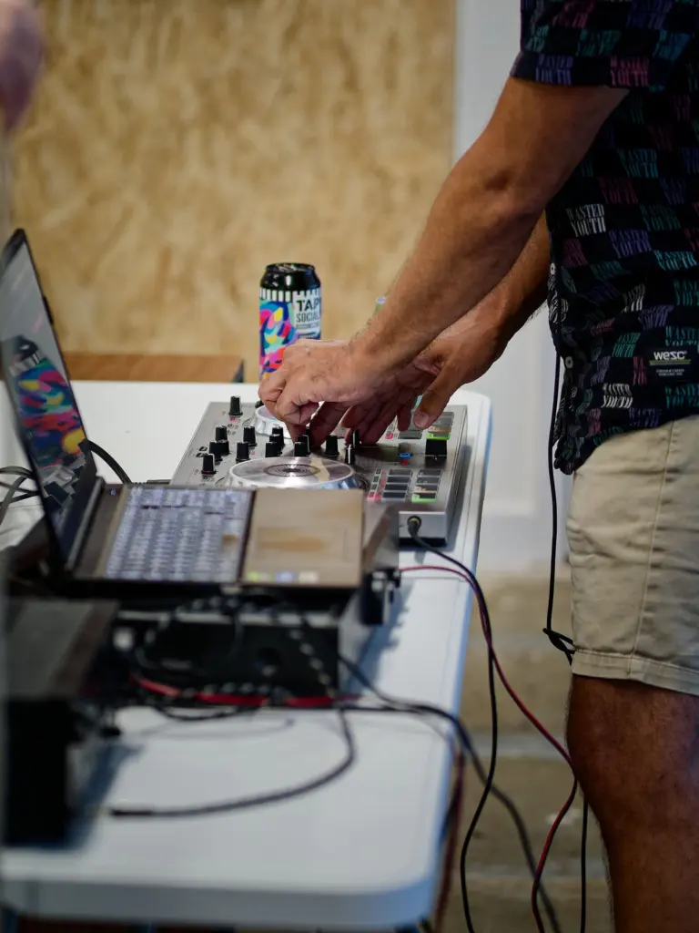 Close-up of hands on the DJ mixer at the opening night