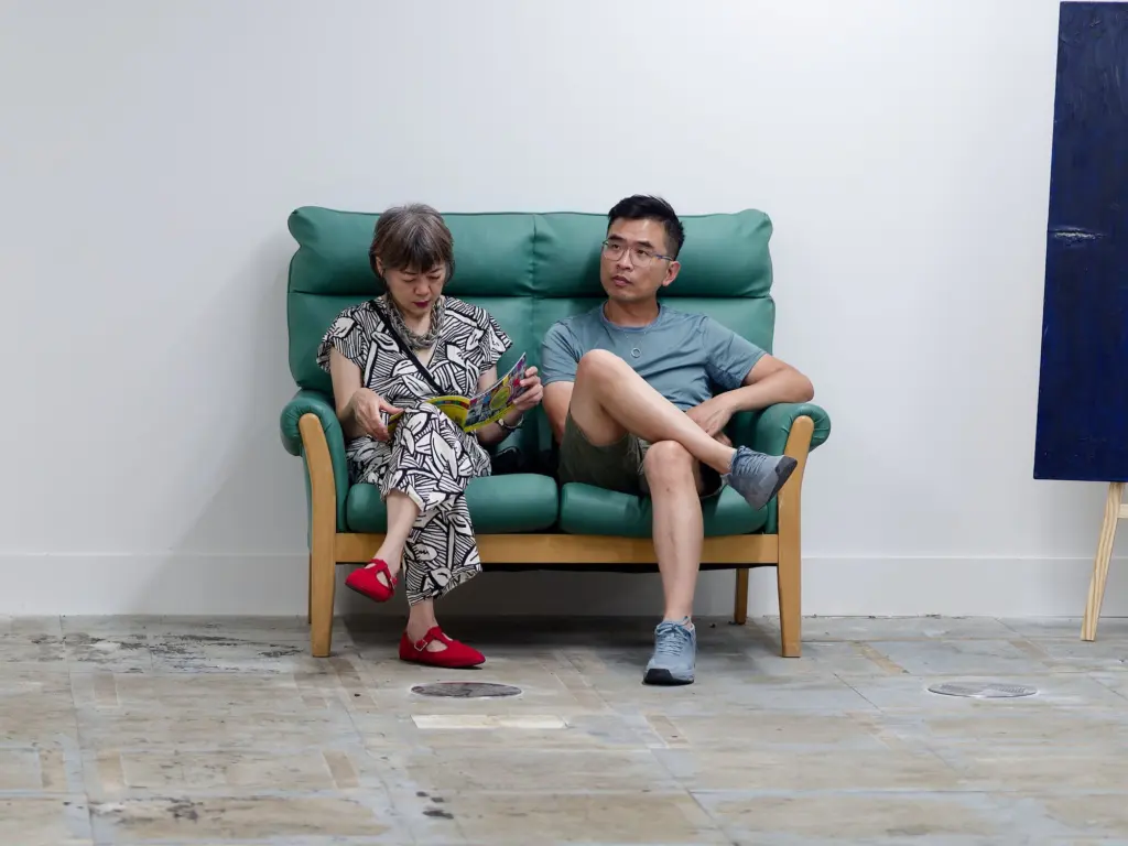 Two guests seated together on a green sofa